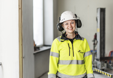 Leende elektriker på byggarbetsplats